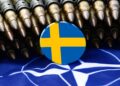 Flags of Sweden and NATO with bullets